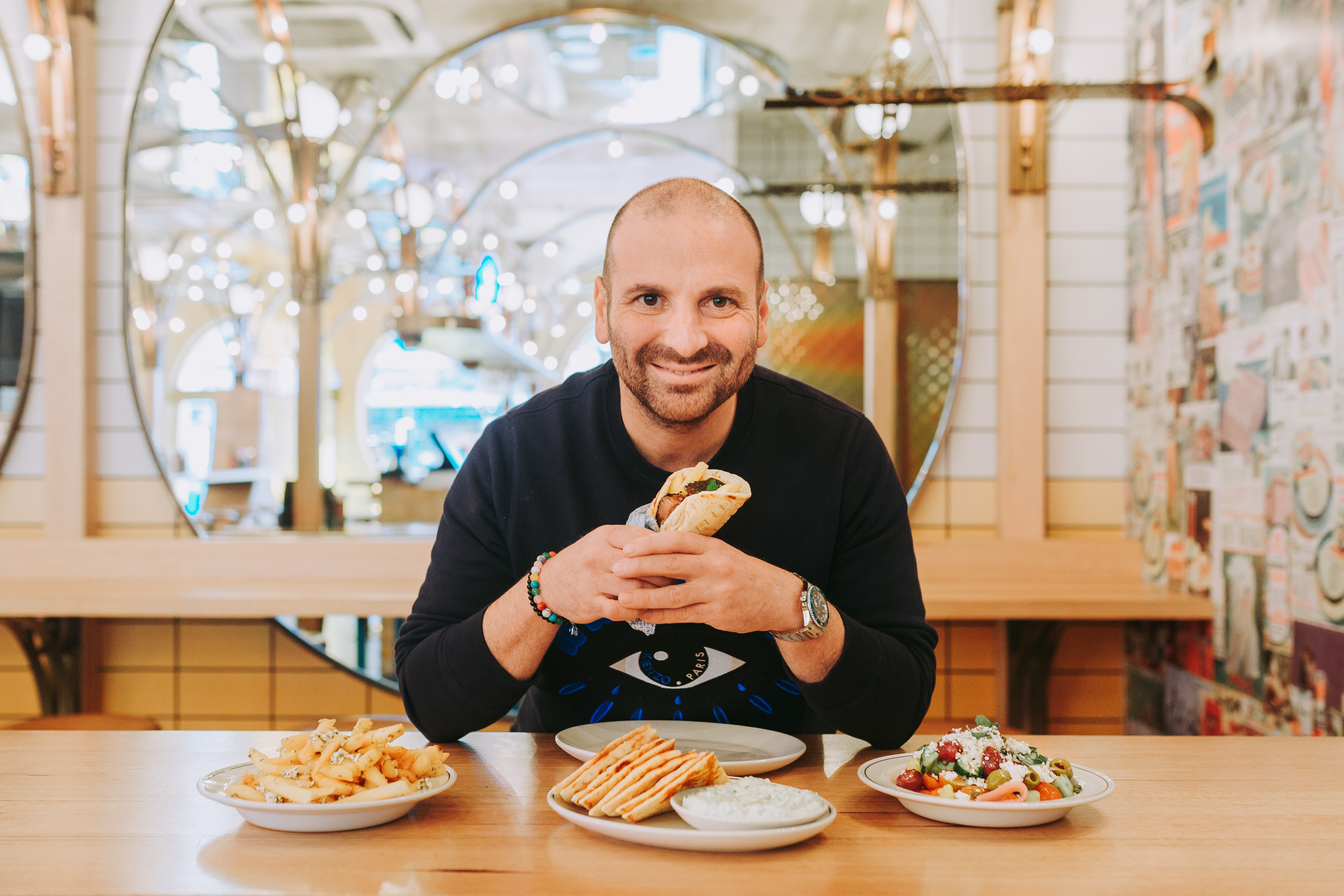 George Calombaris holding a slouvaki in Made Establishment owned jimmy Grants