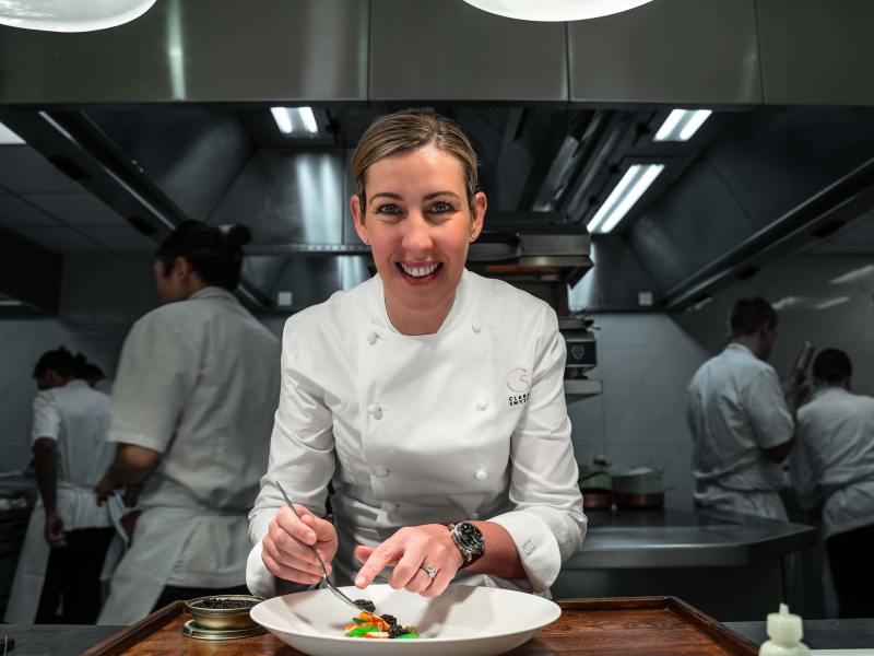 Clare Smyth plating up at a kitchen pass.
