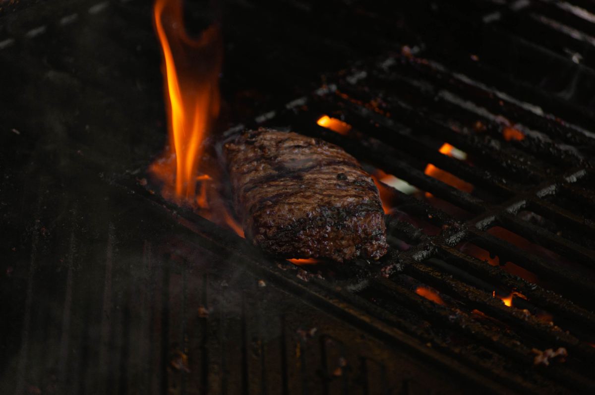 beef on a grill with flames